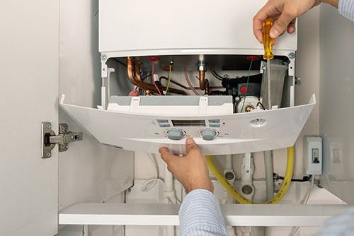 Heating technician repairing a residential boiler in Millbrae
