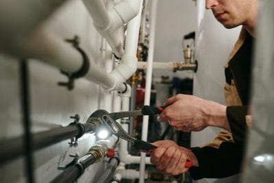 Technician inspecting commercial plumbing pipes in Millbrae