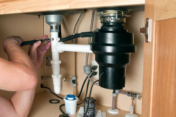 Plumber repairing a garbage disposal in Millbrae