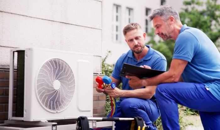 HVAC technicians installing an outdoor air conditioning unit in Millbrae