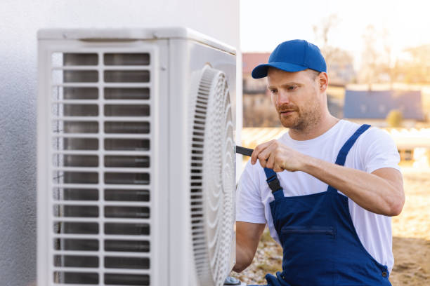HVAC technician servicing an outdoor air conditioner in Millbrae