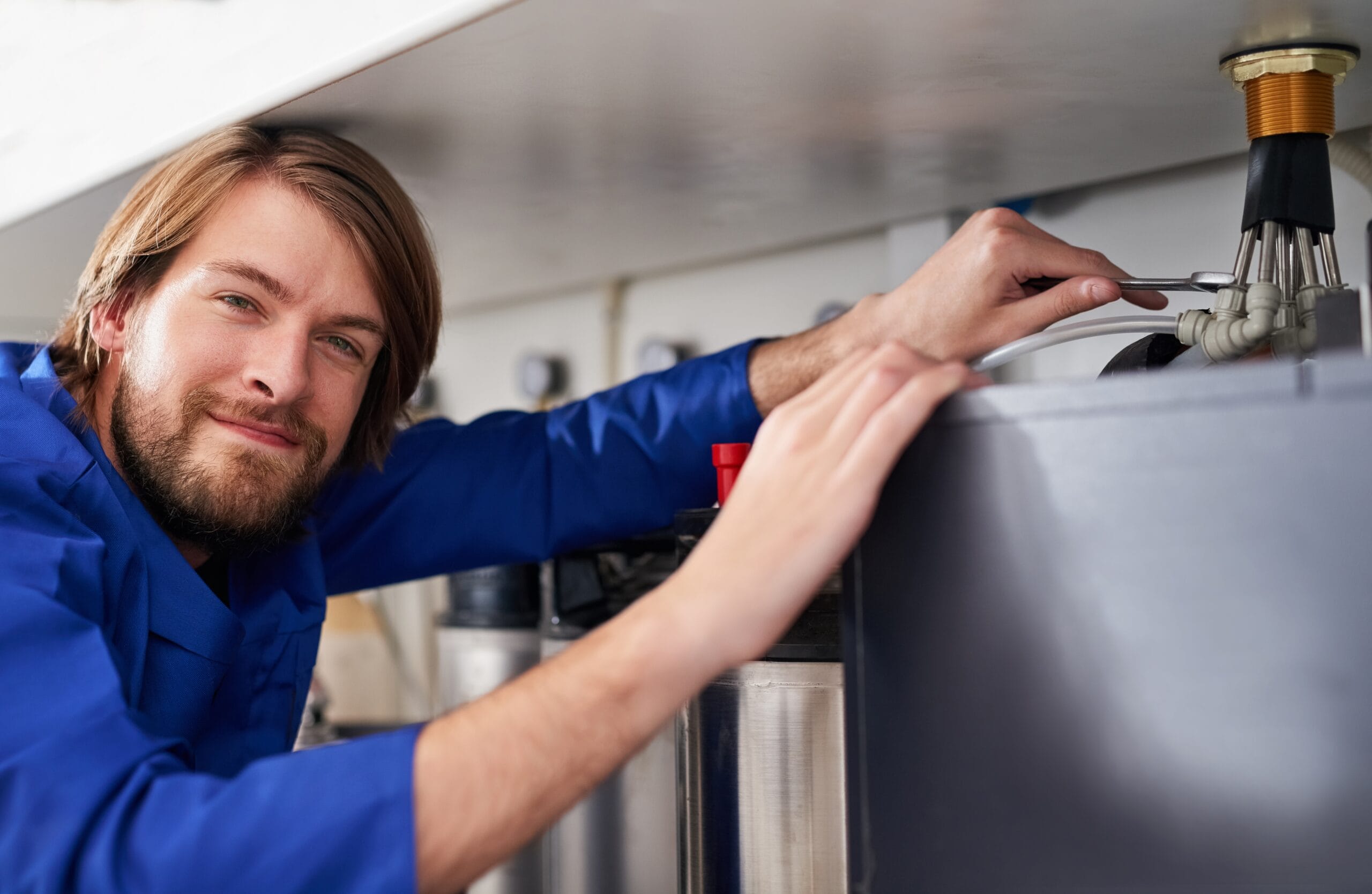 Technician servicing a residential water heater tank in Millbrae